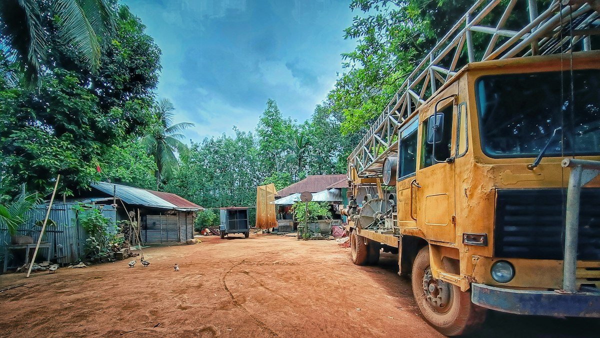 Truck-mounted borewell drilling rig with mast on a rural worksite — OM Enterprise